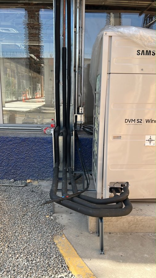 Unidad exterior Samsung DVM S2 de un sistema VRF instalada en Santiago, con las líneas de refrigerante aisladas y sobre soportes
